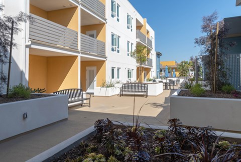 A modern apartment complex with a courtyard and plants.