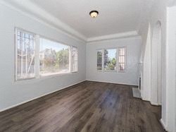 an empty living room with white walls and wood floors
