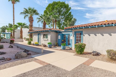 A house with a blue door and a red tile roof.