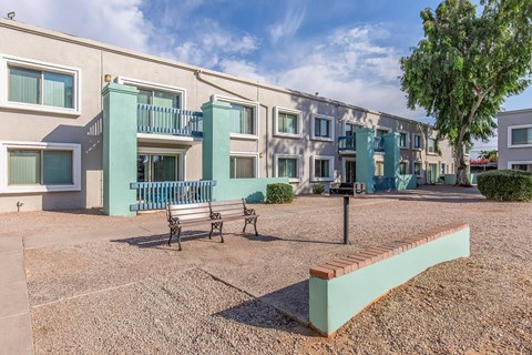 A row of apartment buildings with a bench in front of them.