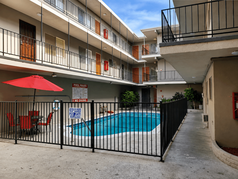 A pool surrounded by a black fence with a sign that says "NO POWER" on it.