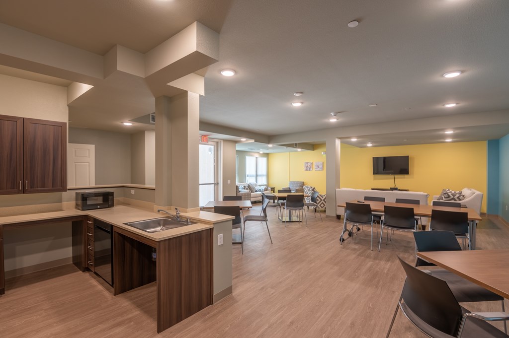 A modern kitchen with a dining area and a TV.