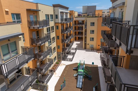 Apartment complex with a playground in the courtyard.