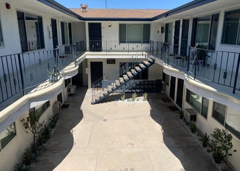 the courtyard of a building with stairs and a pool