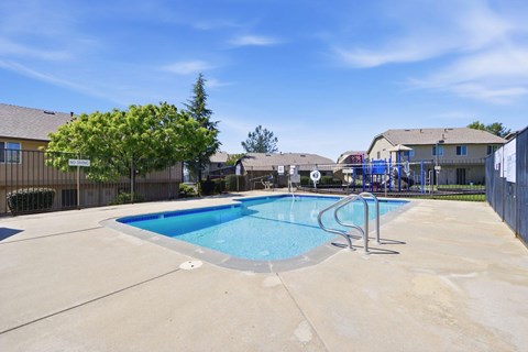 A small pool with a slide in a backyard.