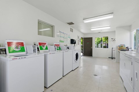 A row of washing machines are lined up in a laundromat.