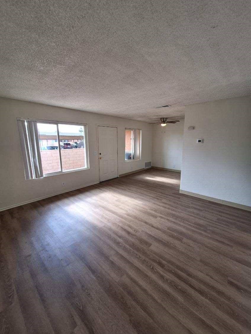 an empty living room with a hard wood floor