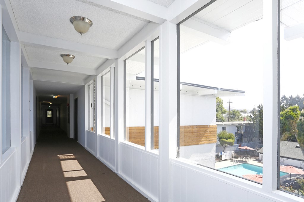 Hallway white walls and windows overlooking pool area