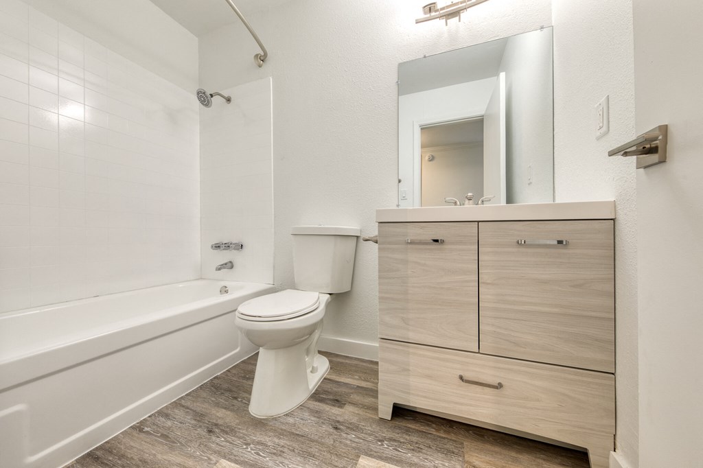 Apartment interior bathroom white cabinet with drawers. Bathtub and toilet