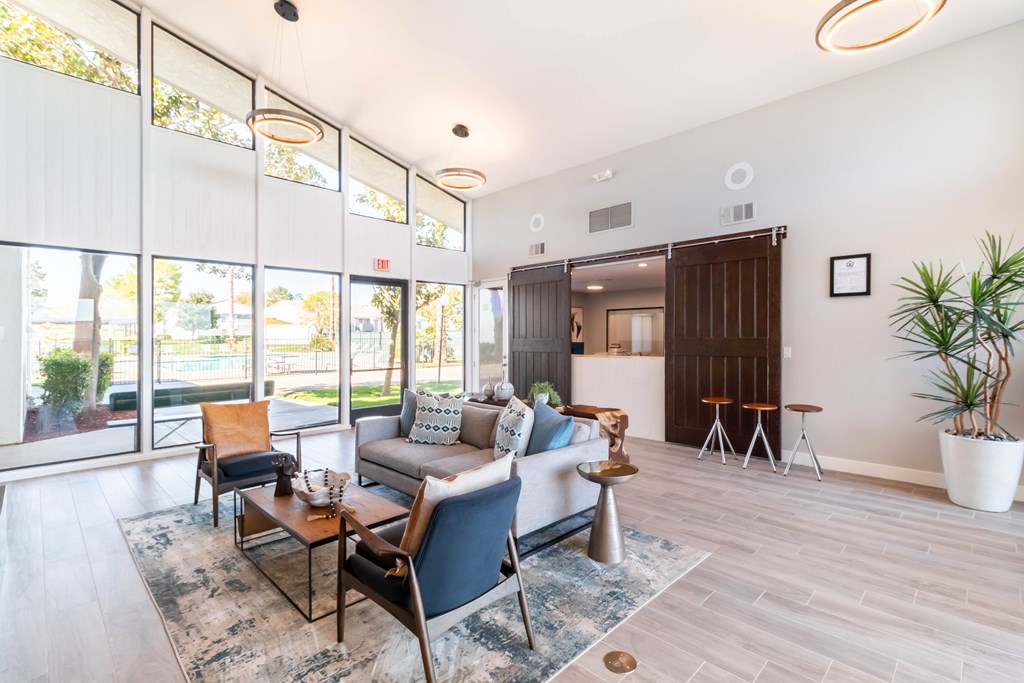 A living room with a couch, chairs, and a rug at Chaparral Apartments, Palmdale, CA