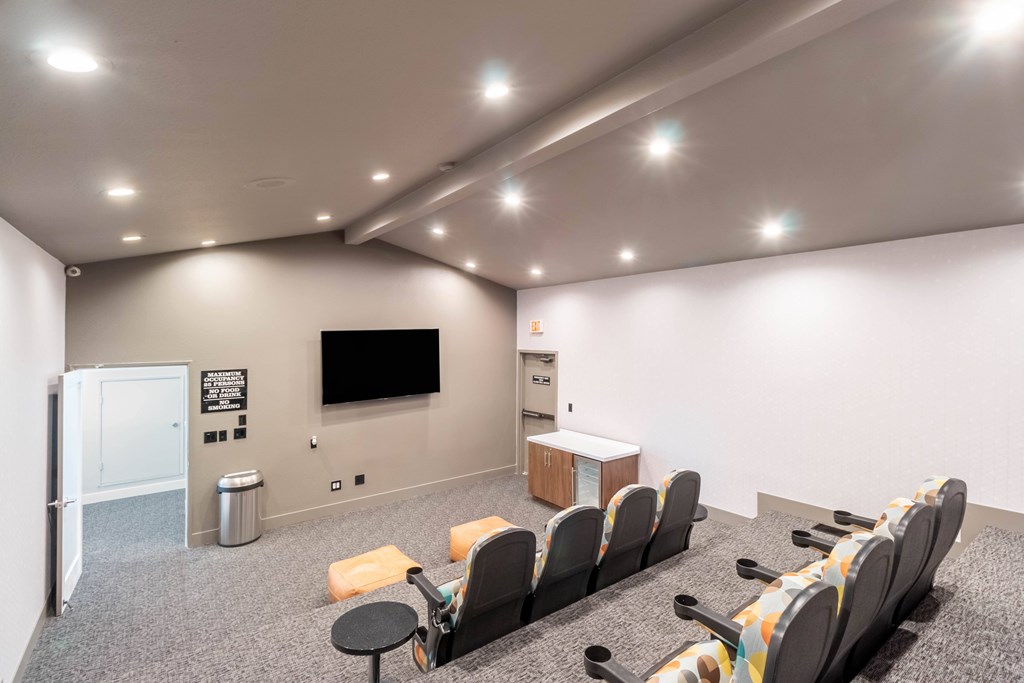 A room with a row of chairs facing a screen at Chaparral Apartments, Palmdale, California