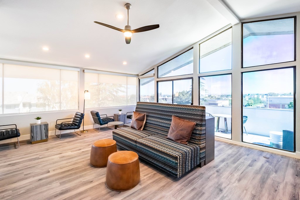 A living room with a striped couch and a ceiling fan at Chaparral Apartments, Palmdale 93551