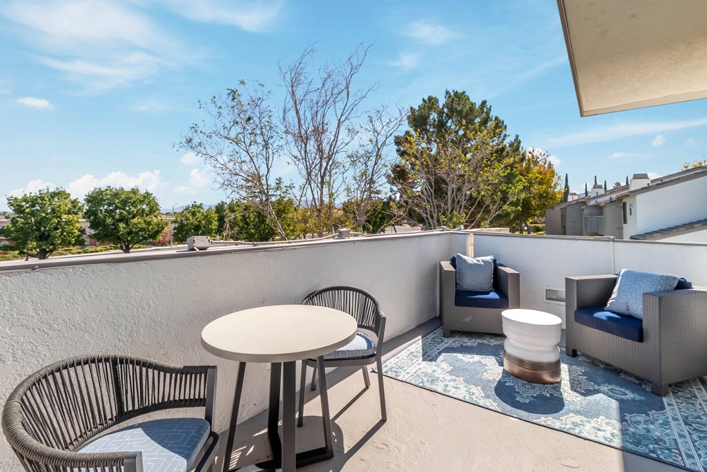 A patio with a table, chairs, and a couch at Chaparral Apartments, Palmdale