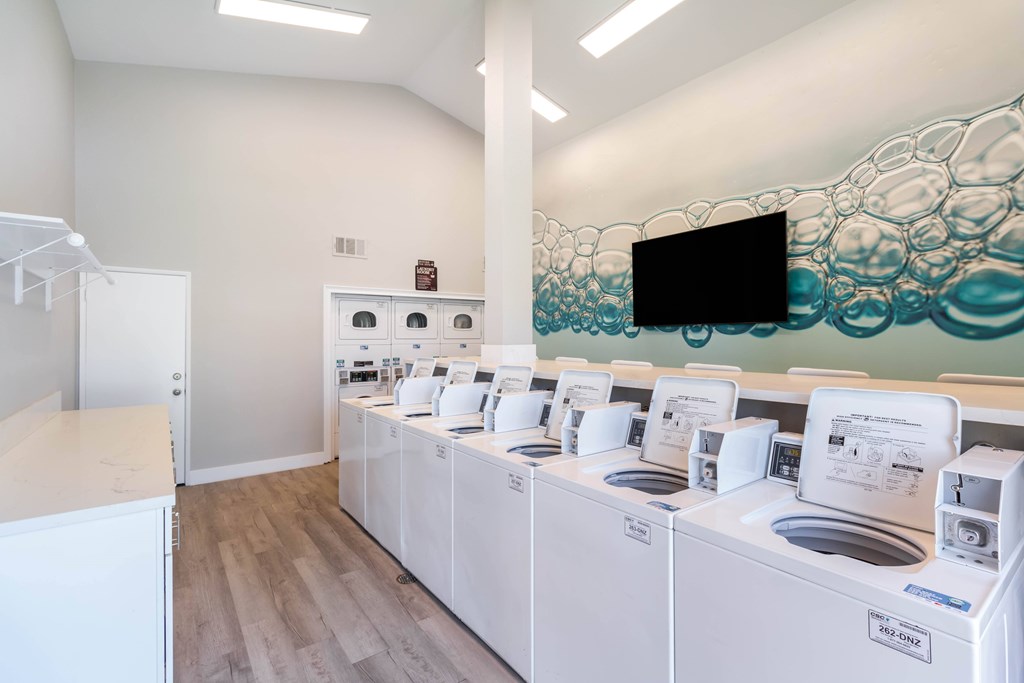 A row of washing machines are lined up in a laundromat at Chaparral Apartments, California