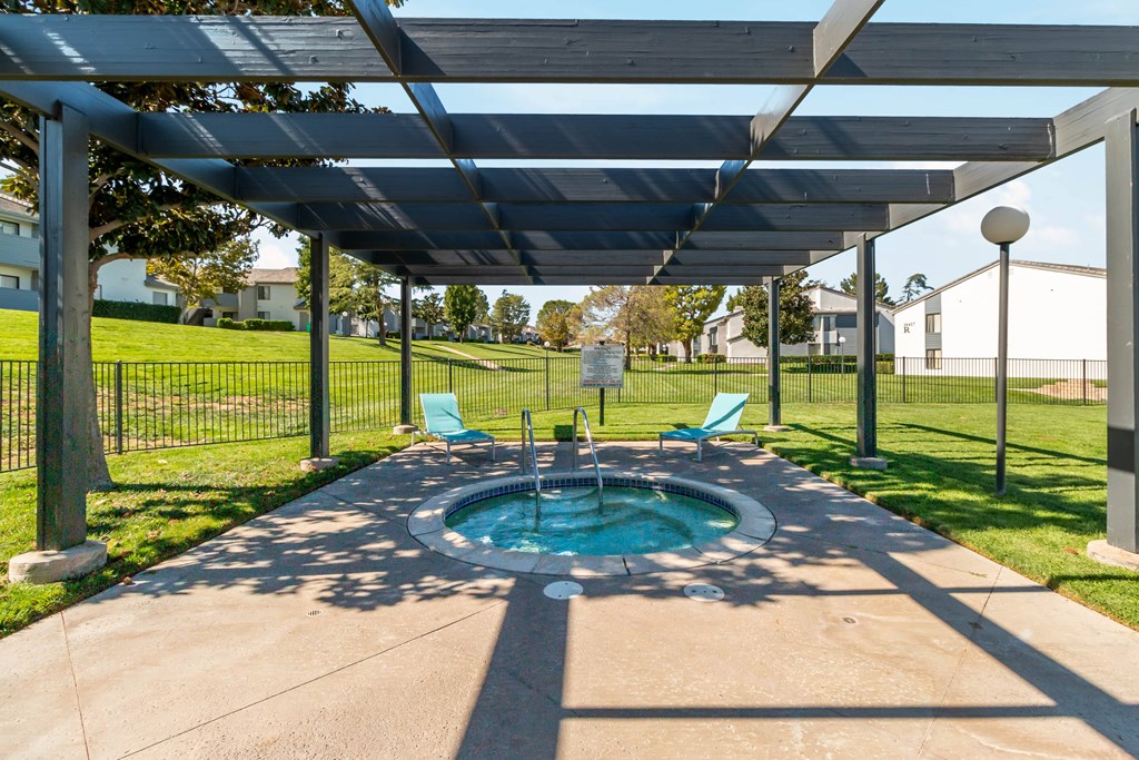 A hot tub is under a canopy in a backyard at Chaparral Apartments, Palmdale