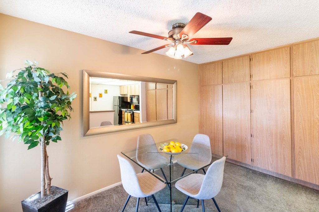 A dining room with a glass table and chairs. at Chaparral Apartments, Palmdale 93551