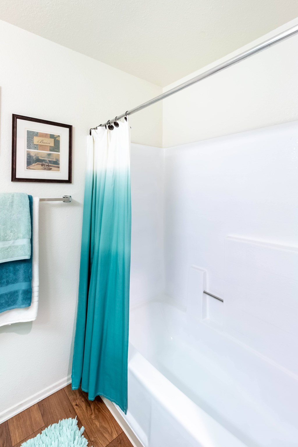 A white bathroom with a blue shower curtain.