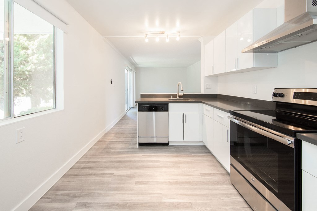Apartment Interior kitchen black and stainless steal appliances, white cabinets.