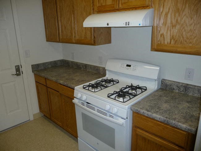 a white stove top oven sitting inside of a kitchen