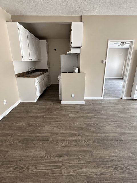A kitchen with white cabinets and a refrigerator.
