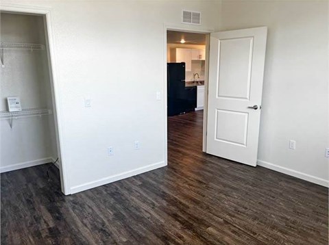 A room with a black fridge and a white door.