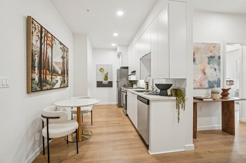 A modern kitchen with a dining table and chairs.