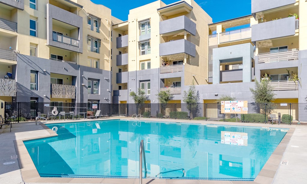 a swimming pool in front of an apartment building