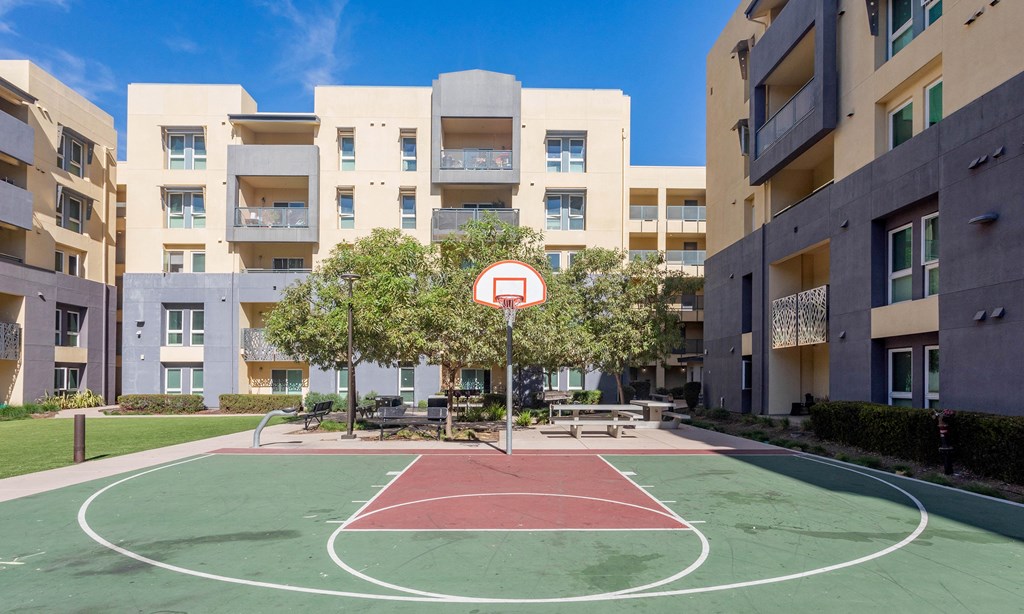 an outdoor basketball court in front of an apartment building