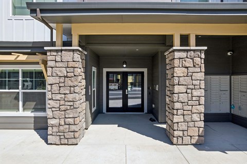 A building with a stone pillar and a glass door.