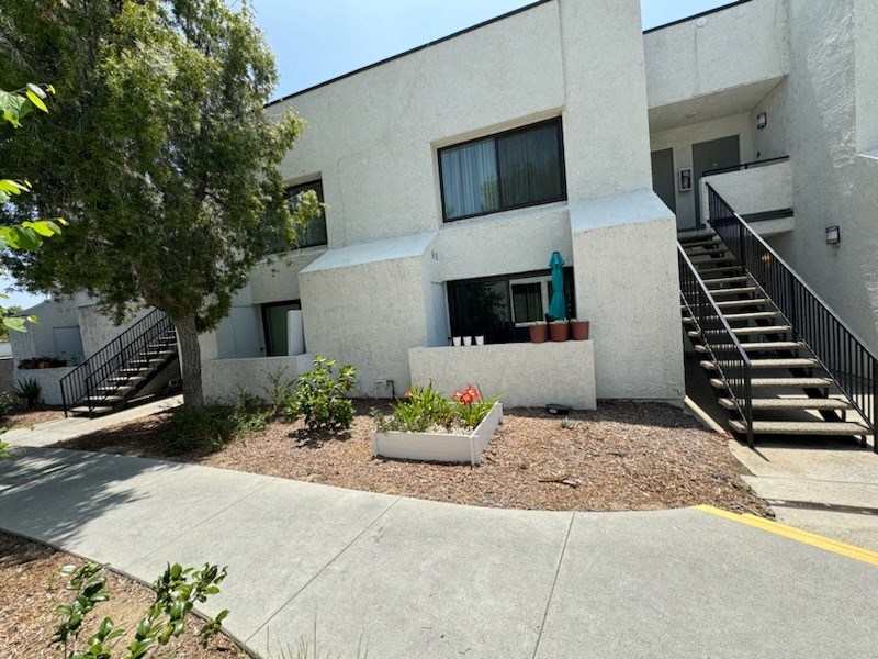 an exterior view of a white building with stairs