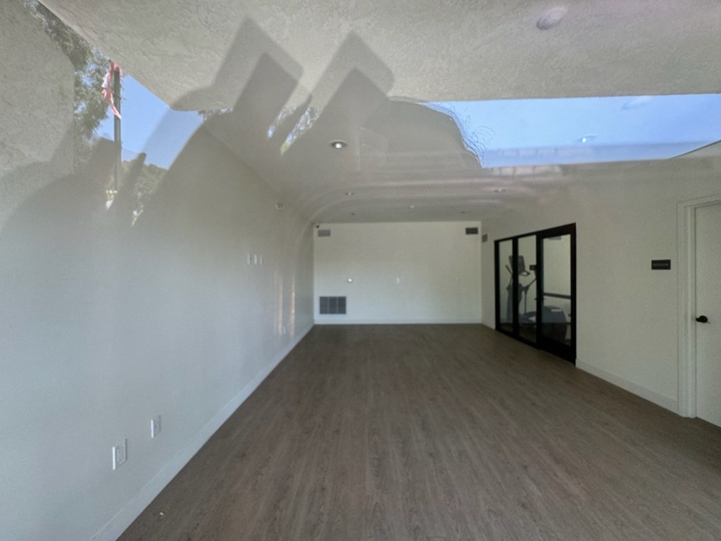 community room with white walls and wood floors