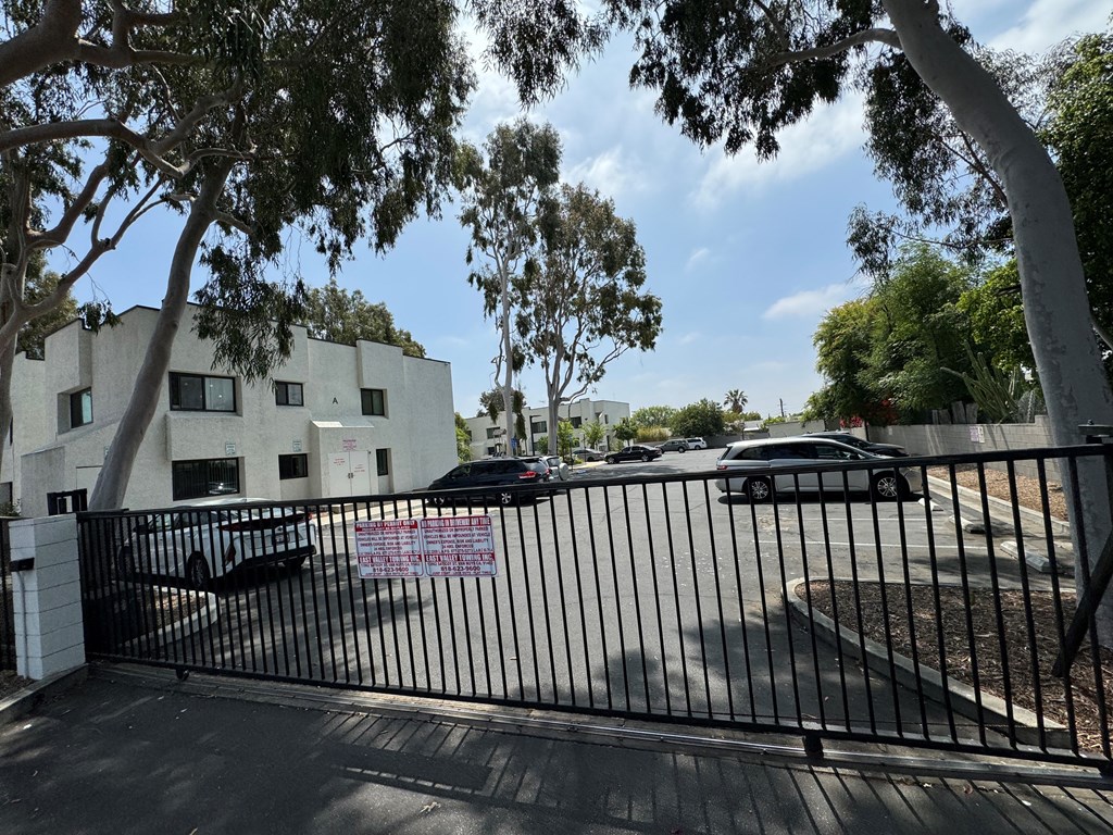 a gate with cars parked in front of a building