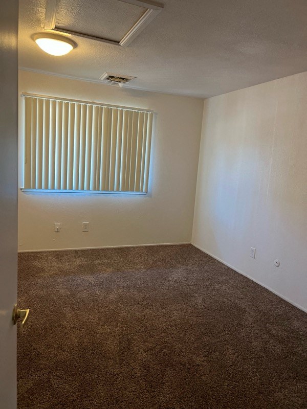 an empty room with a window and a carpet