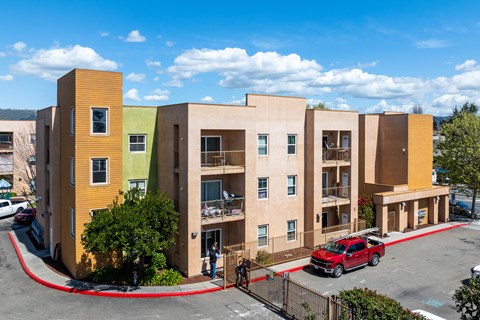 A red car is parked in front of a building.
