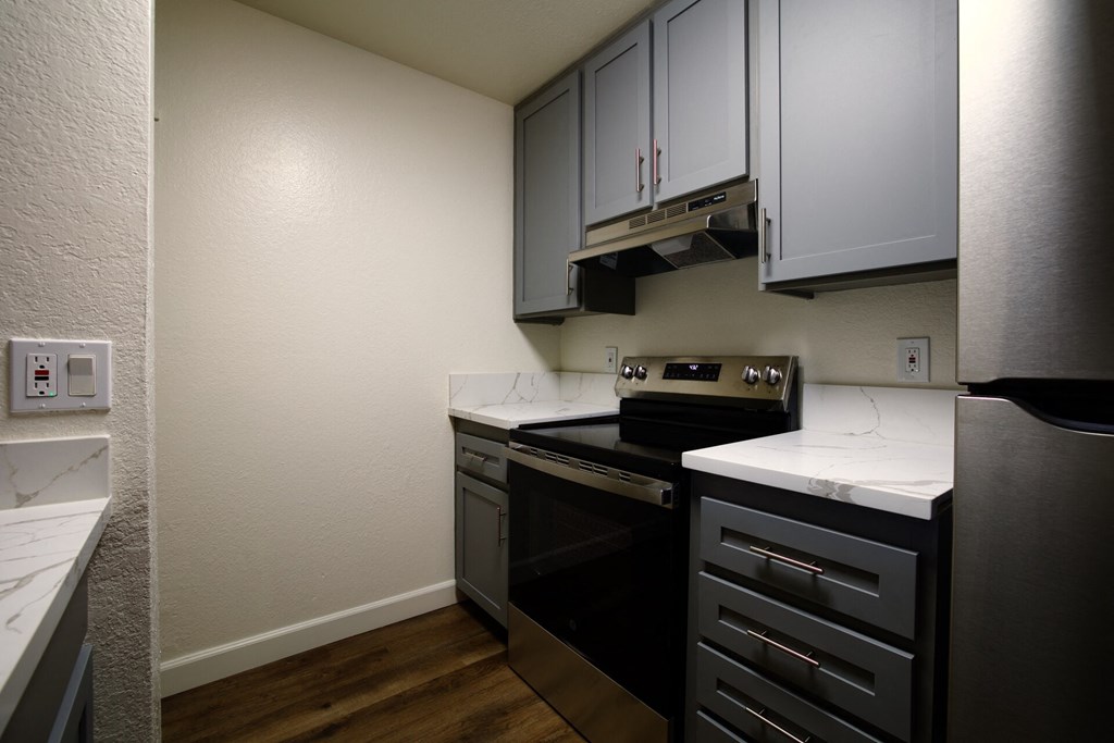 an empty kitchen with black appliances and white counter tops at Brookhollow Apartments, West Covina , California