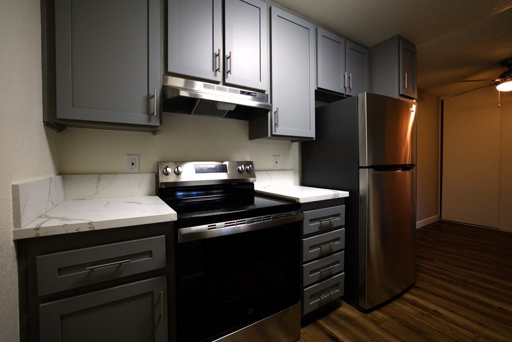 a kitchen with black appliances and white counter tops at Brookhollow Apartments, West Covina , California