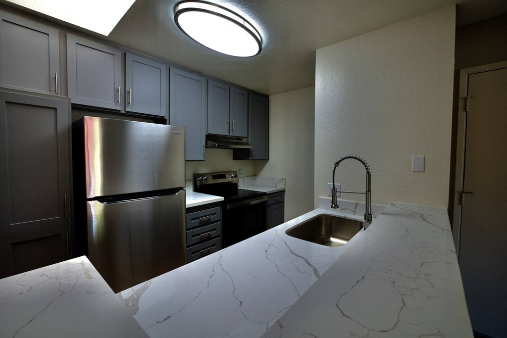a kitchen with a sink and a refrigerator at Brookhollow Apartments, West Covina , California