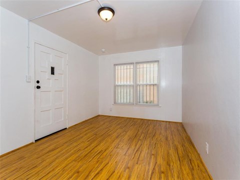 an empty living room with wood floors and a white door