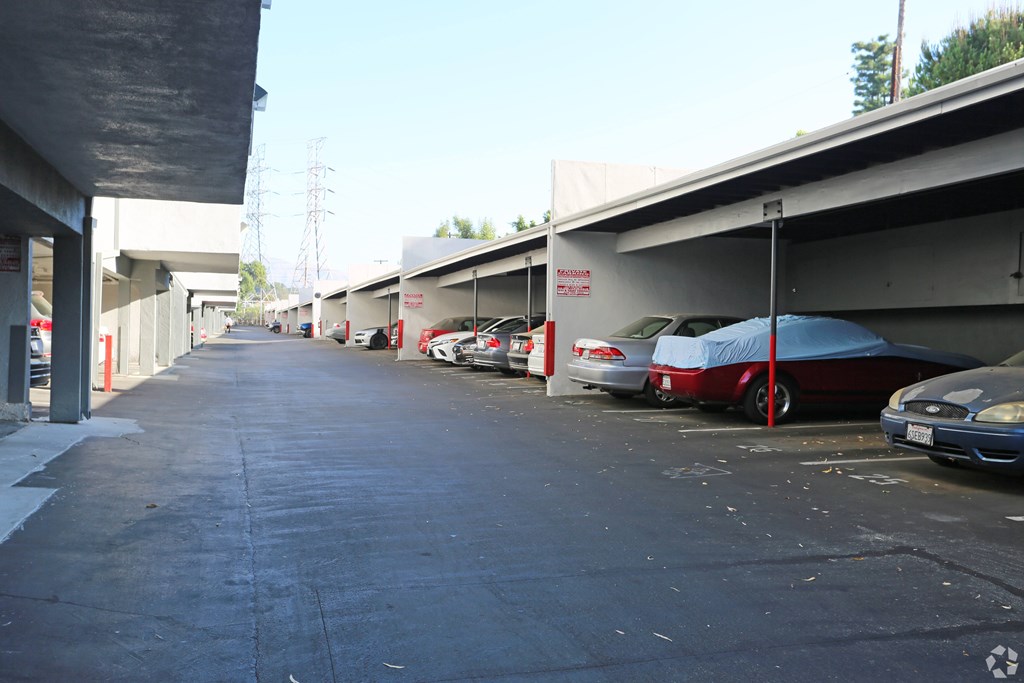 A parking lot with cars and a blue umbrella.