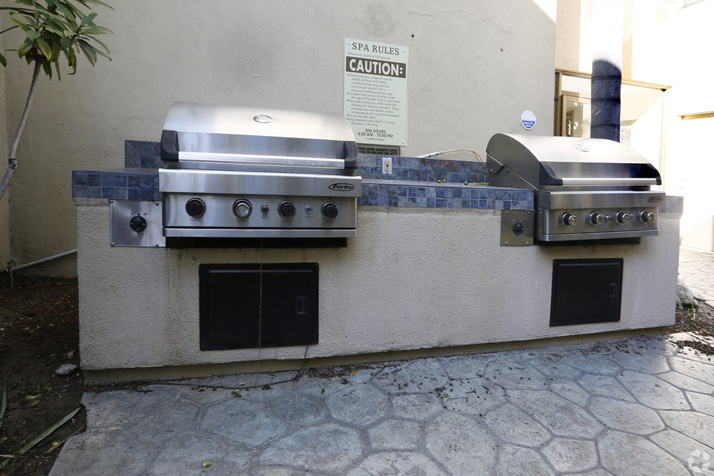 A stainless steel grill with a caution sign on the wall.