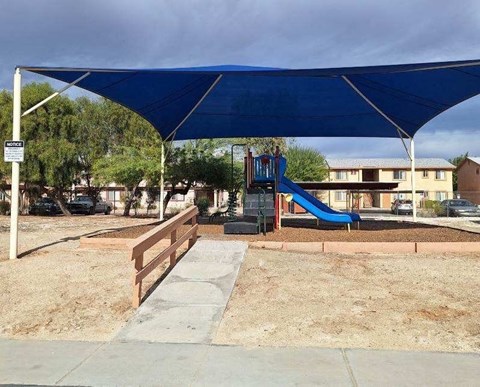 a blue canopy over a playground in a park