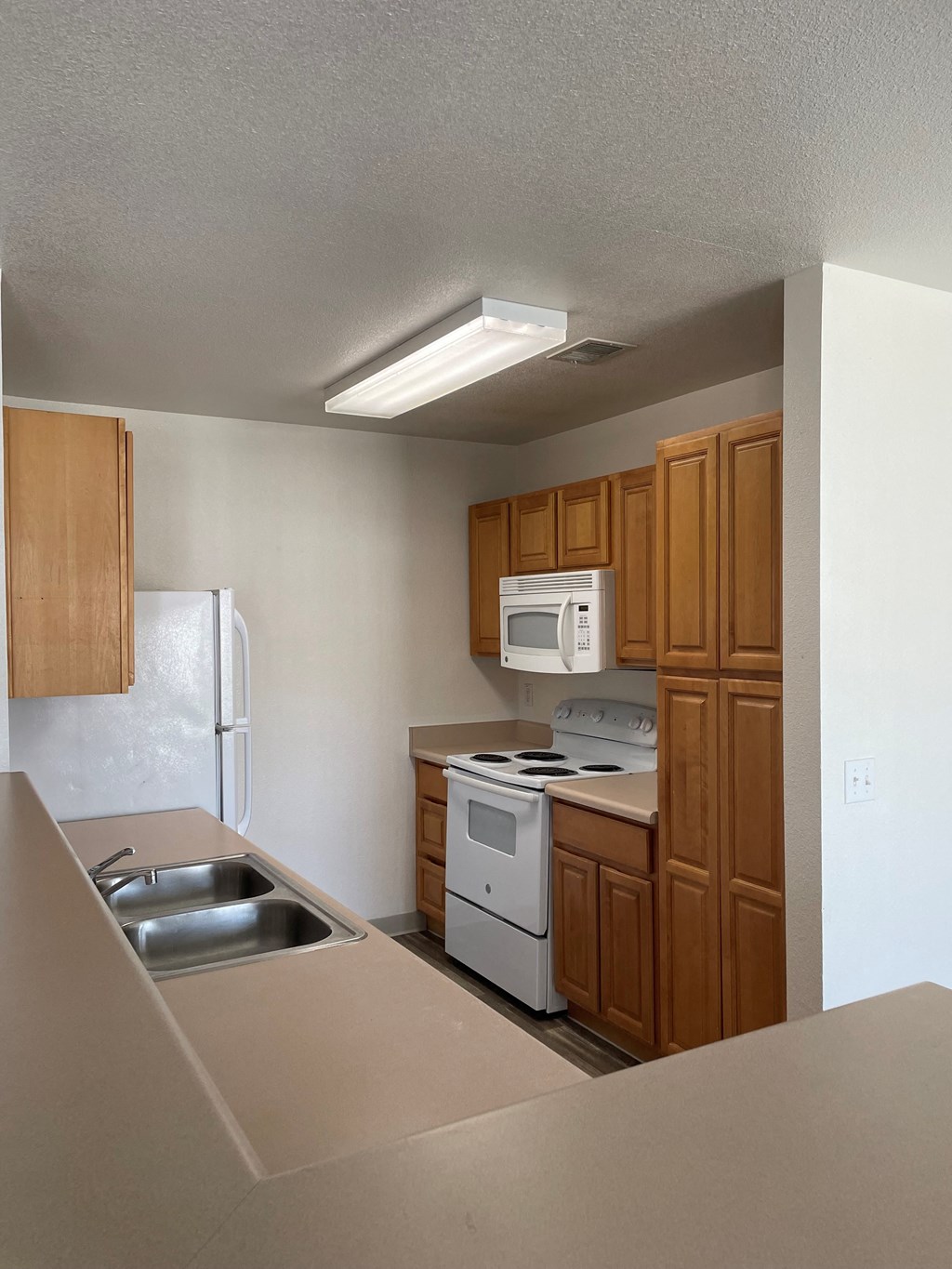 a small kitchen with white appliances and wooden cabinets