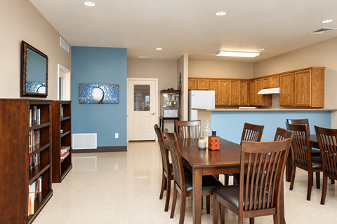 A dining room with a wooden table and chairs.