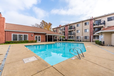 A swimming pool in a residential area with a building in the background.