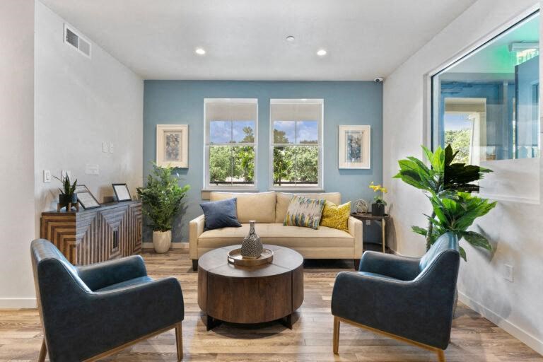 a living room with blue walls and a couch and chairs
