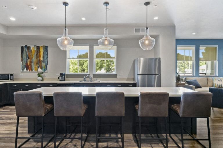 a kitchen with an island and chairs and a refrigerator