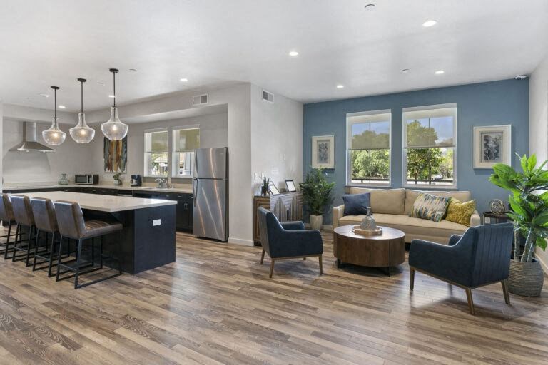 a community room with a kitchen and a table and chairs