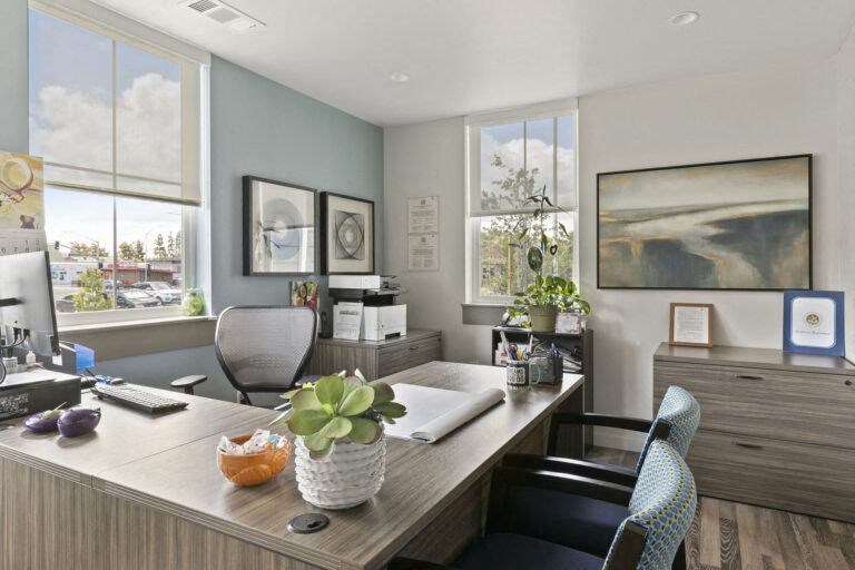 a community office with a wooden desk and a computer