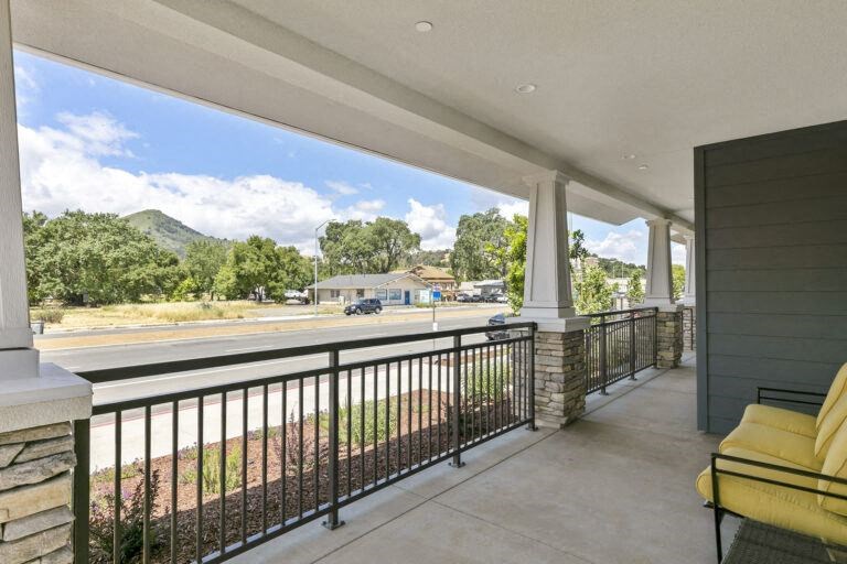a balcony with a view of a parking lot and a house