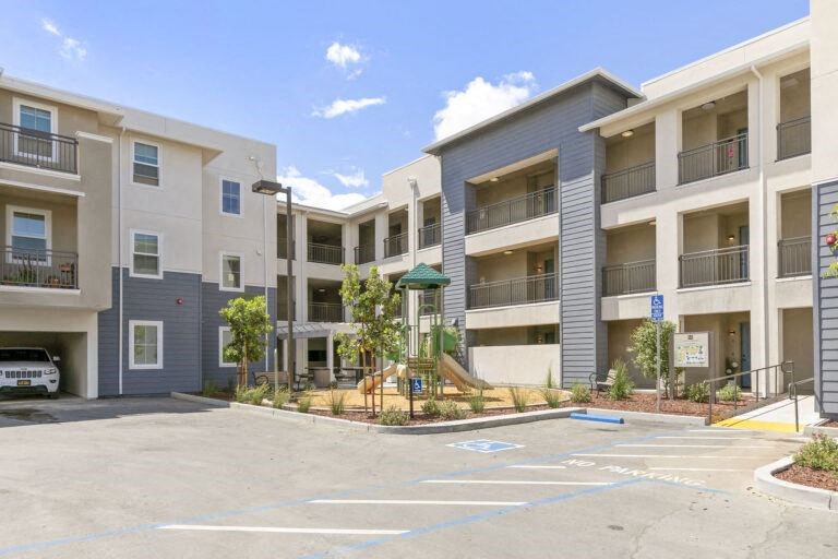 an empty parking lot in front of an apartment building